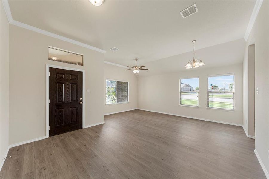 Foyer entrance featuring wood-type flooring, ceiling fan with notable chandelier, and ornamental molding