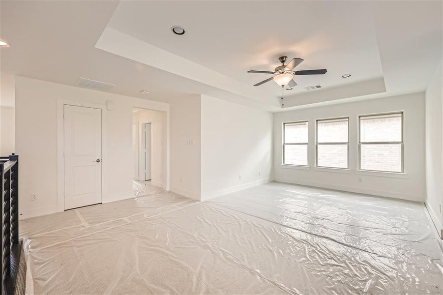 Spare room with a tray ceiling and ceiling fan