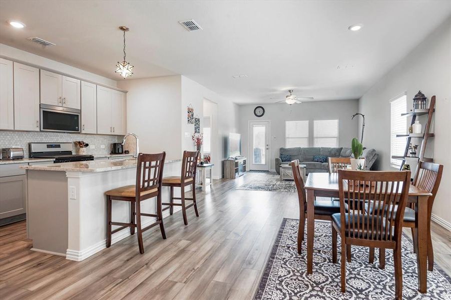 Dining space featuring light hardwood / wood-style floors, sink, ceiling fan, and plenty of natural light