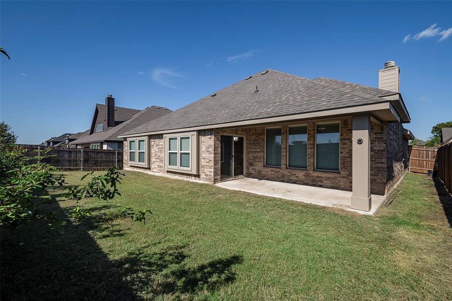 Back of house with a patio and a lawn