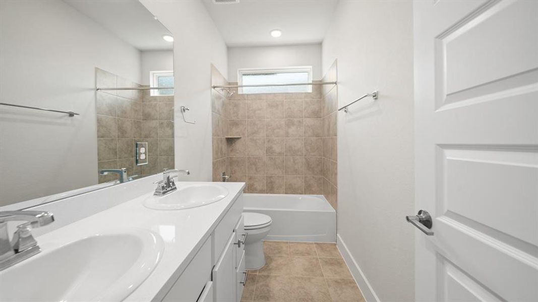 This full bathroom is located between the secondary bedrooms making it easy to share and get ready. It features a large dual vanity, white cabinets, quartz countertops, and a large combination tub and shower.