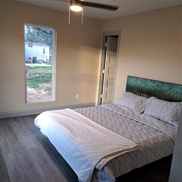 Bedroom with dark hardwood / wood-style floors and ceiling fan