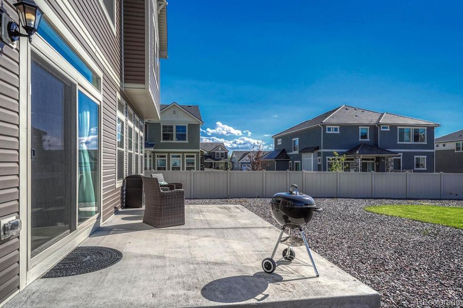 A patio with a spacious backyard, perfect for hosting gatherings.