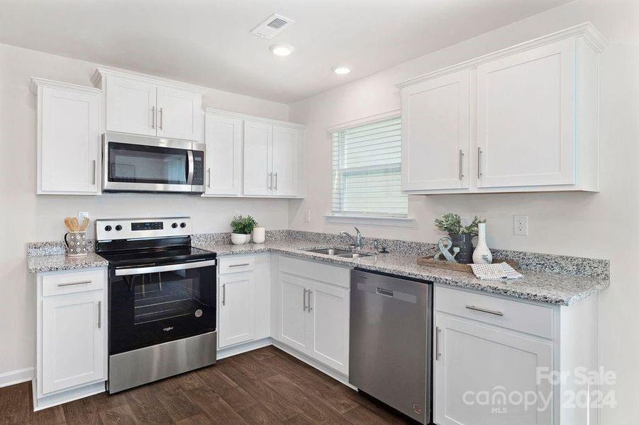 Kitchen features granite countertops and all stainless steel appliances