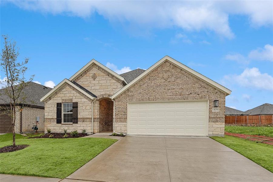 View of front of property with a garage and a front yard