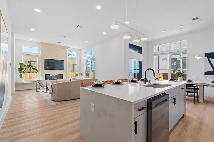 This expansive kitchen and living area is the ultimate combination of style and efficiency. The large quartz island provides ample space for culinary creativity and entertaining, while the open floor plan and floor-to-ceiling windows ensure a bright, open feel. The living room, featuring a sleek fireplace, completes the space—ideal for relaxed family time or hosting guests with ease.