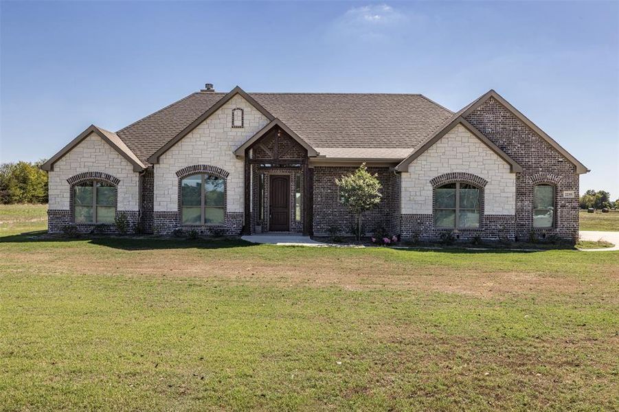 French provincial home featuring a front yard