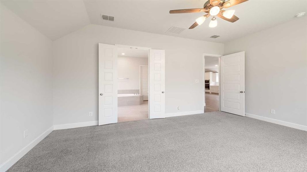 Unfurnished bedroom featuring ensuite bath, carpet, ceiling fan, and lofted ceiling