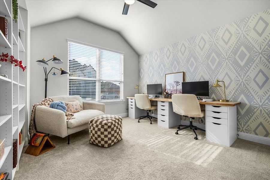 Home office with ceiling fan, light colored carpet, and lofted ceiling