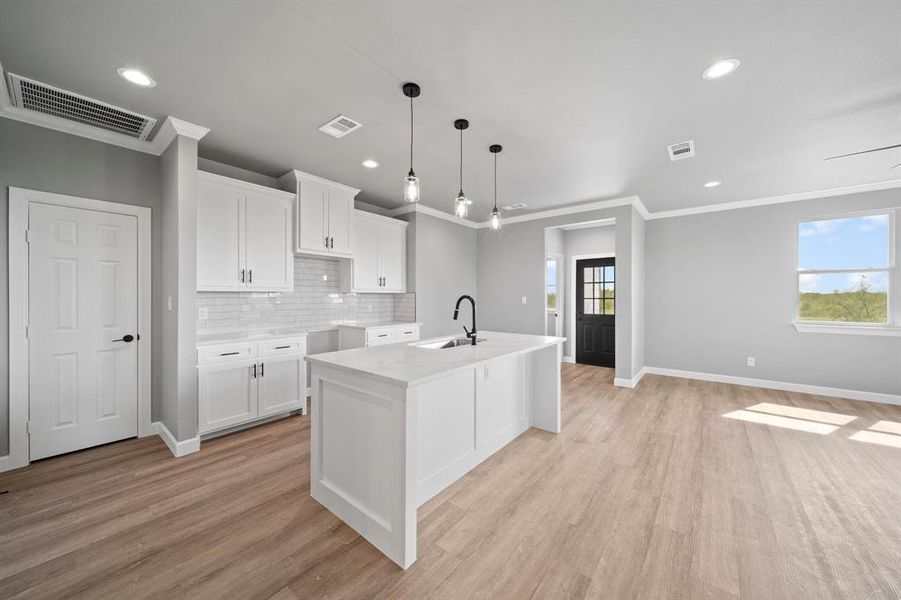 Kitchen featuring a healthy amount of sunlight, white cabinets, and light hardwood / wood-style floors