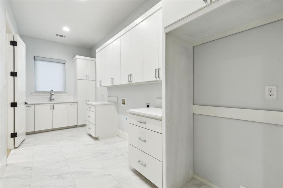 Look at this huge utility room with sink, broom closet, ample cabinets and room for fridge!