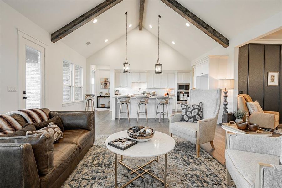 Living room featuring wood-type flooring, beamed ceiling, and high vaulted ceiling