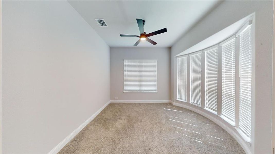 Carpeted spare room with ceiling fan