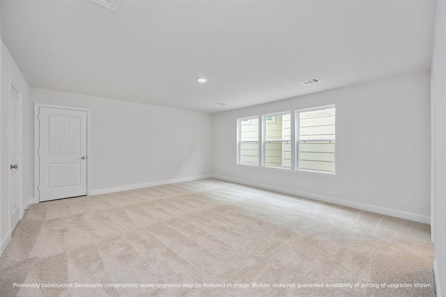 A remarkably large third-floor bedroom basks in brightness, featuring an ensuite bathroom and access to a substantial walk-in storage closet, ensuring privacy and comfort.