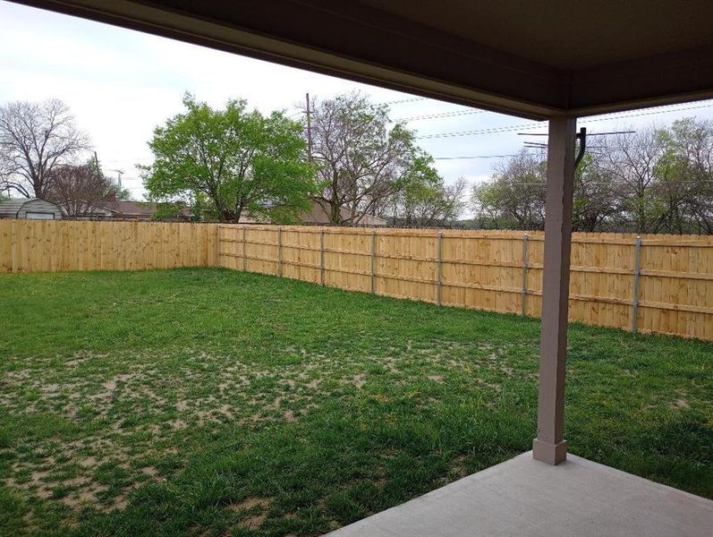 View of 75 feet deep yard with covered patio area.