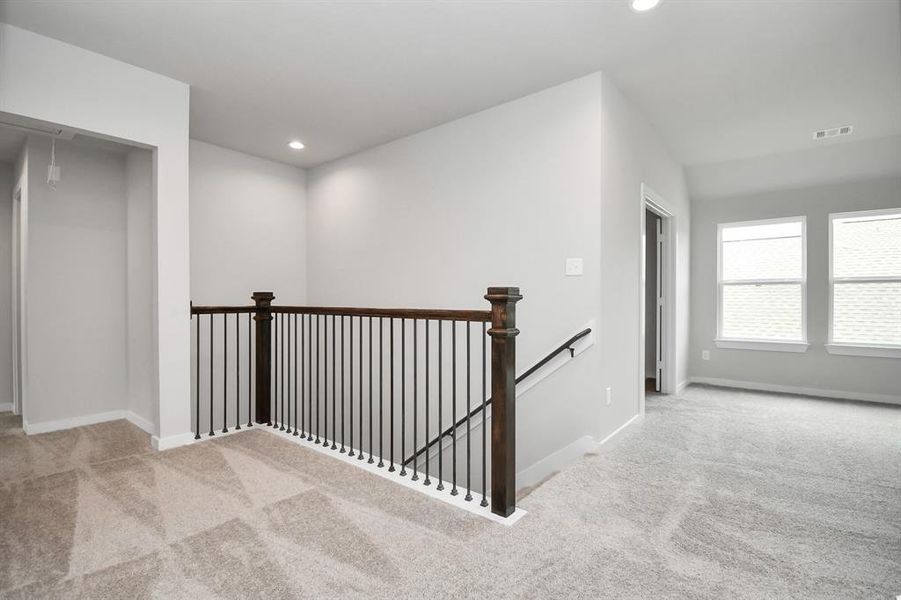 Come upstairs and enjoy a day of leisure in this fabulous game room! This is the perfect hangout spot or adult game room! Features plush carpet, high ceilings, custom paint and windows for plenty of natural light. Sample photo, actual color and selections can vary.