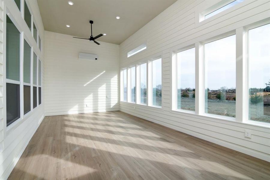 Unfurnished sunroom featuring ceiling fan