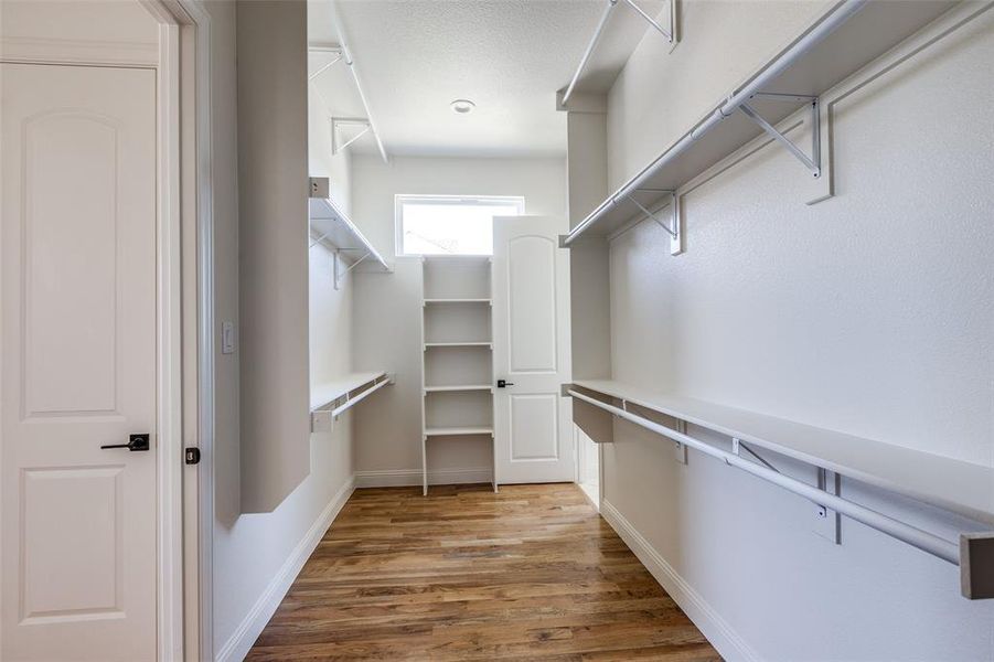 Spacious closet with light hardwood / wood-style flooring