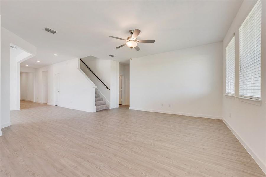 Unfurnished living room with light hardwood / wood-style floors and ceiling fan