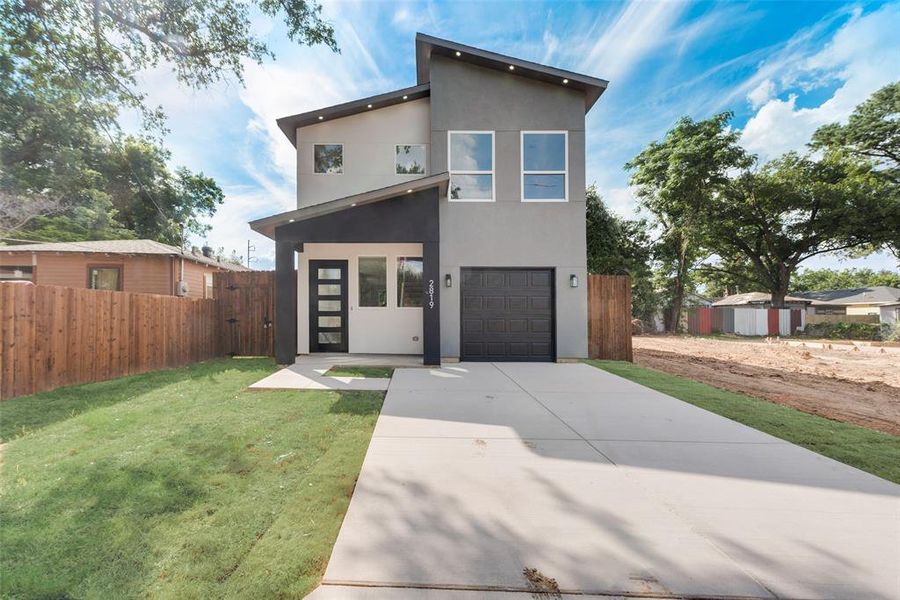 Contemporary home with a garage and a front lawn