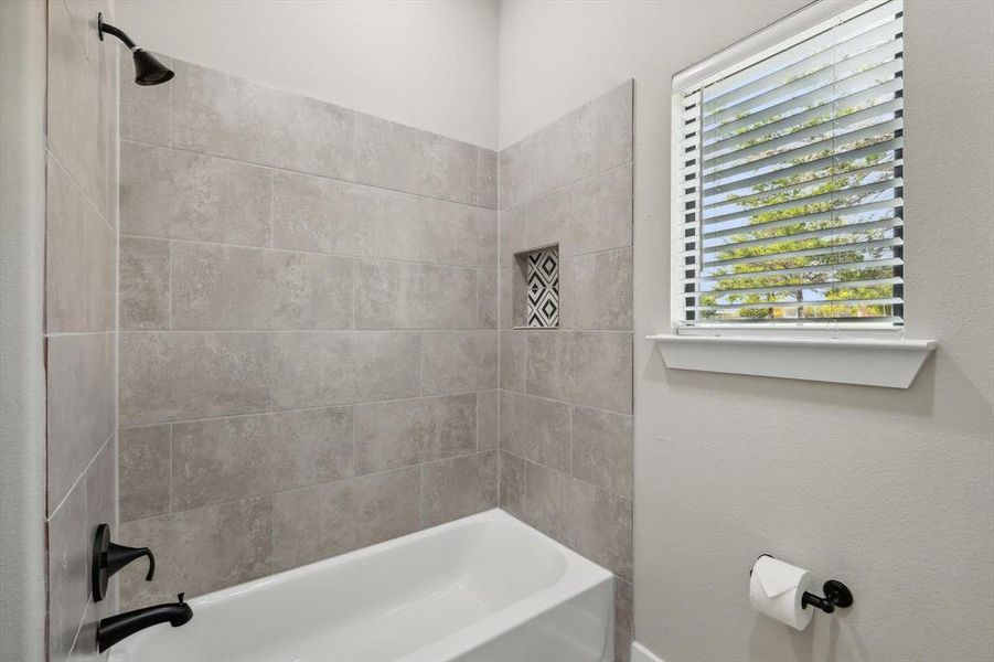 Bathroom featuring plenty of natural light and tiled shower / bath combo