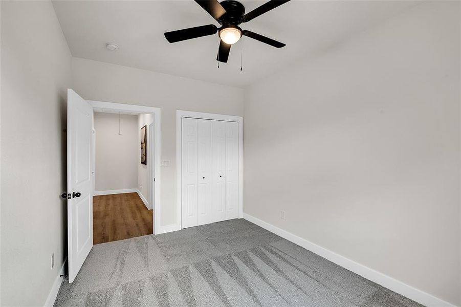 Bedroom with a closet, carpet, and ceiling fan