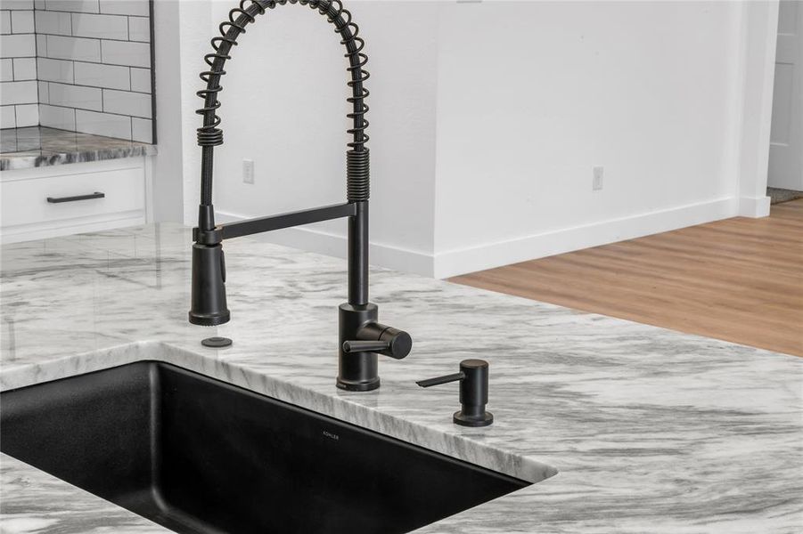 Details with wood-type flooring, light stone counters, and sink