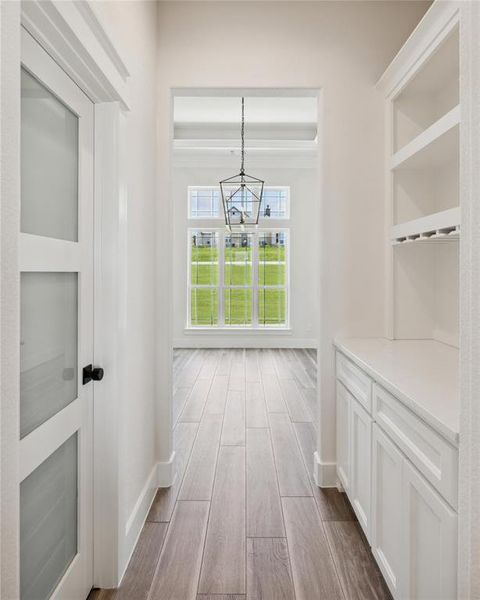 Corridor with a notable chandelier and hardwood / wood-style floors