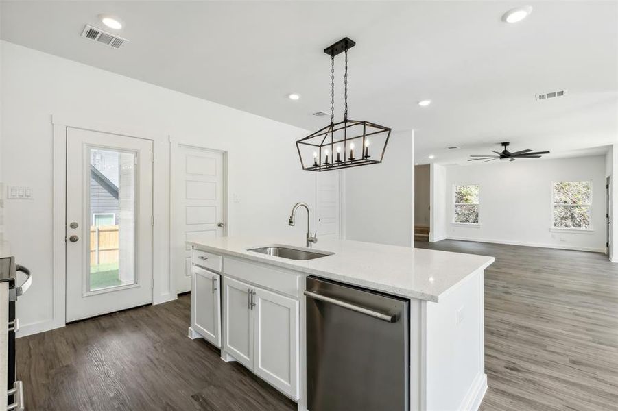 Kitchen featuring sink, ceiling fan with notable chandelier, stainless steel dishwasher, and dark wood-type flooring