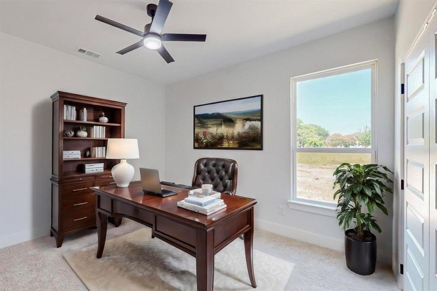 Carpeted office featuring ceiling fan