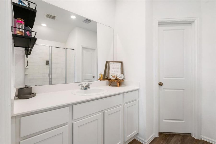 Primary bathroom has lots of counter space and cabinets and an extra large shower.