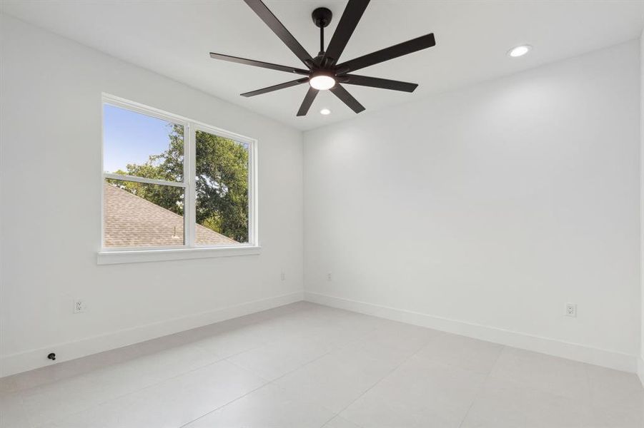 Spare room with ceiling fan and light tile floors