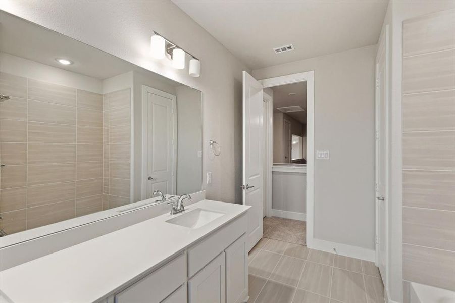 Bathroom featuring a shower, tile patterned floors, and vanity