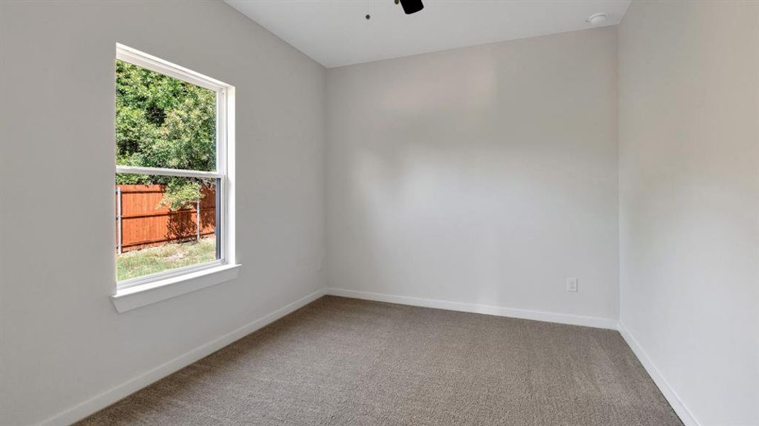 Empty room with ceiling fan and carpet flooring