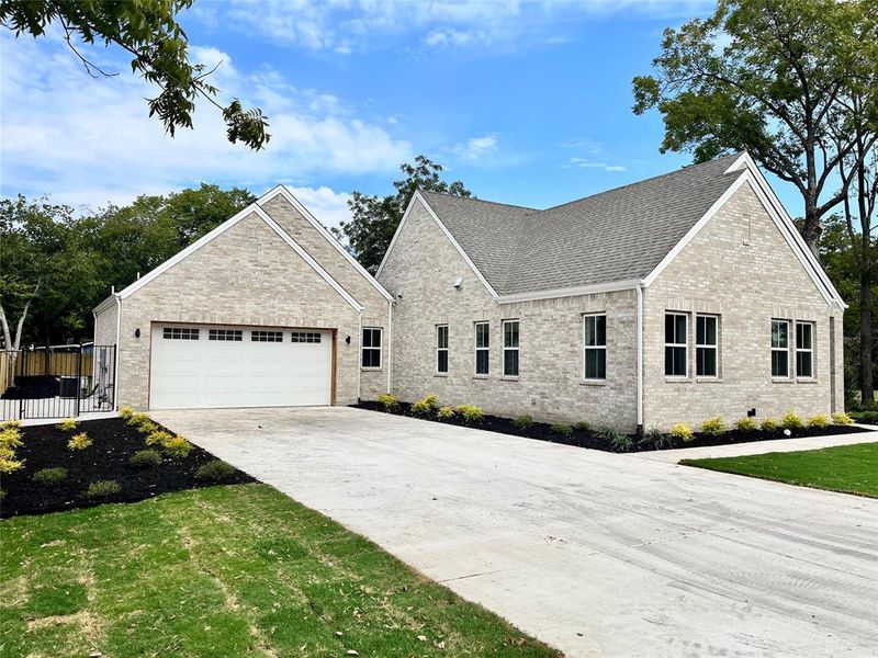 View of front of property featuring a front yard and a garage