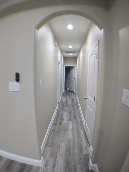 Hallway with hardwood / wood-style floors