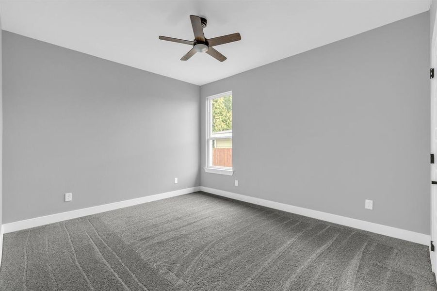 Empty room featuring ceiling fan and carpet flooring