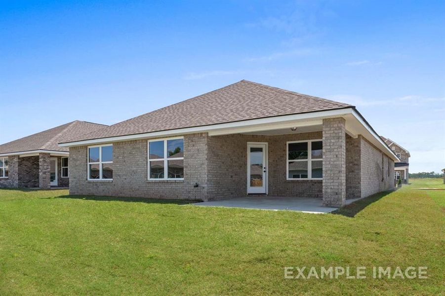 Back of house featuring a lawn and a patio area