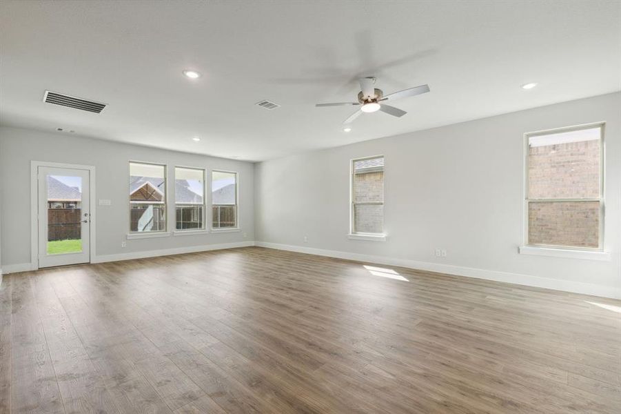 Unfurnished room with light wood-type flooring, plenty of natural light, and ceiling fan