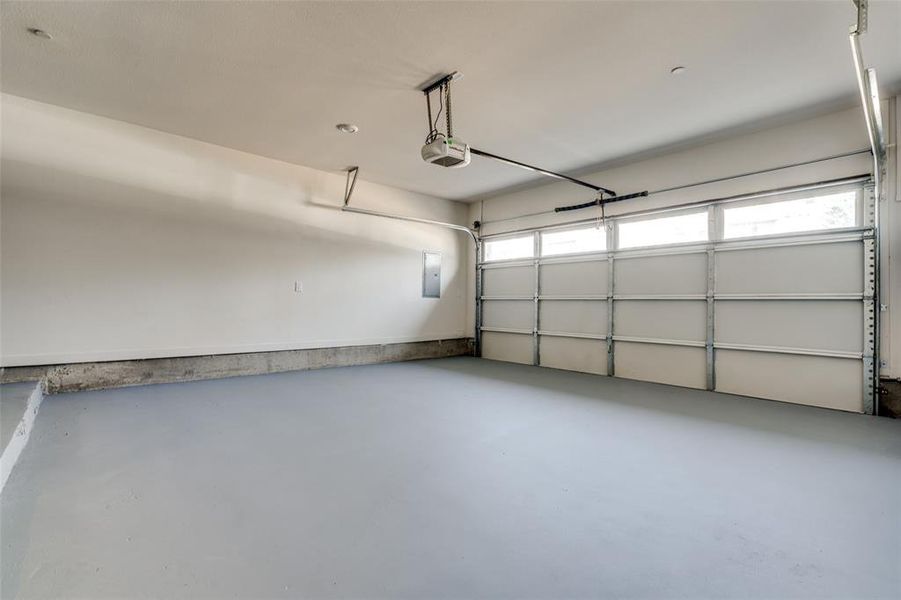 Garage with an Expoxy Floor, Tankless Water Heater, and Single Garage Door