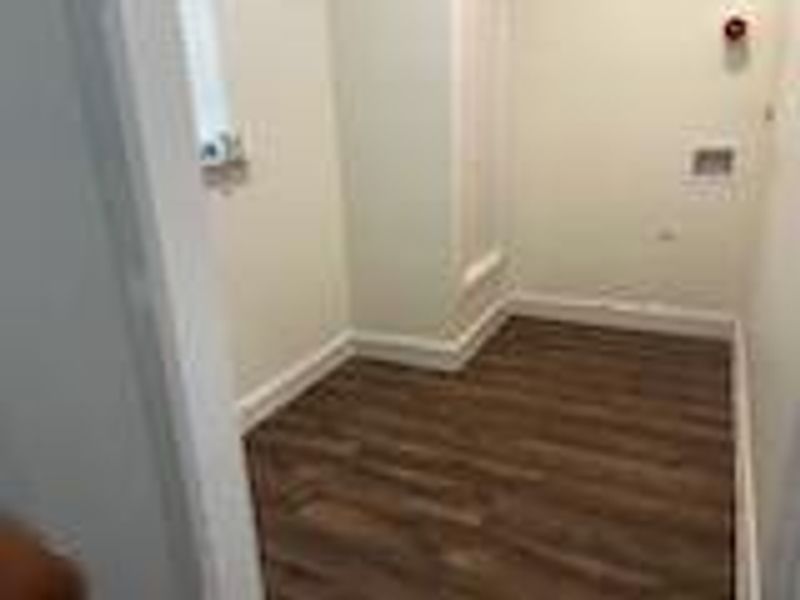 Clothes washing area featuring hardwood / wood-style floors