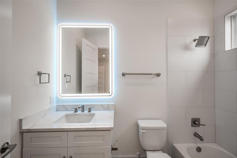 Secondary bedroom’s ensuite bath with quartz vanity and tub/shower combo.