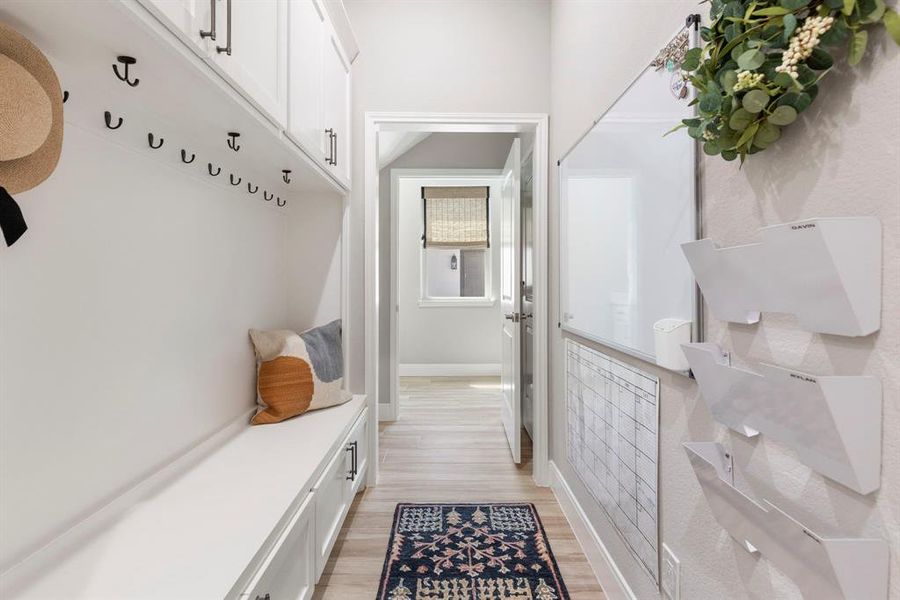 Look at this functional built-in mud room directly off the garage! Perfect for your kids shoes/backpacks to hang and tuck away items without the clutter.