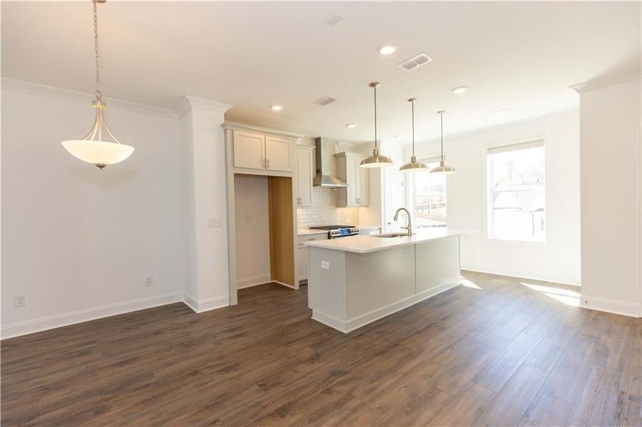 On the main level, the dining area leads to the kitchen.**Photos of model house and not of actual home - Photos for representation purposes only **