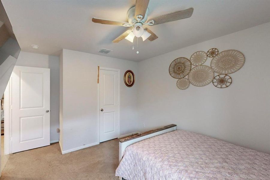 Bedroom with ceiling fan and light colored carpet