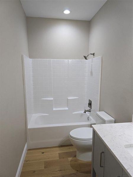 Full bathroom with vanity, hardwood / wood-style floors, toilet, and shower / washtub combination