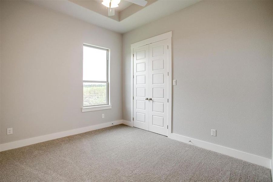 Carpeted spare room featuring ceiling fan