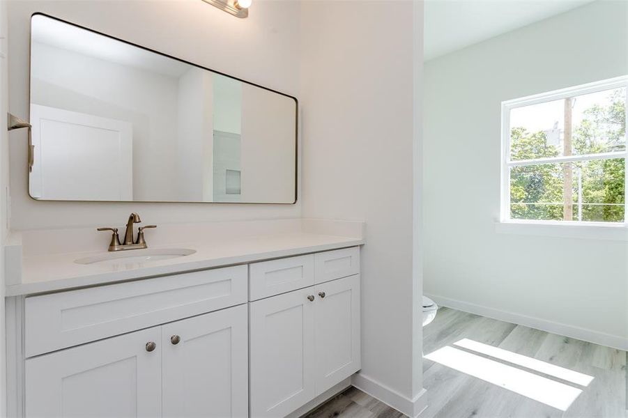 Bathroom featuring vanity, toilet, and hardwood / wood-style flooring