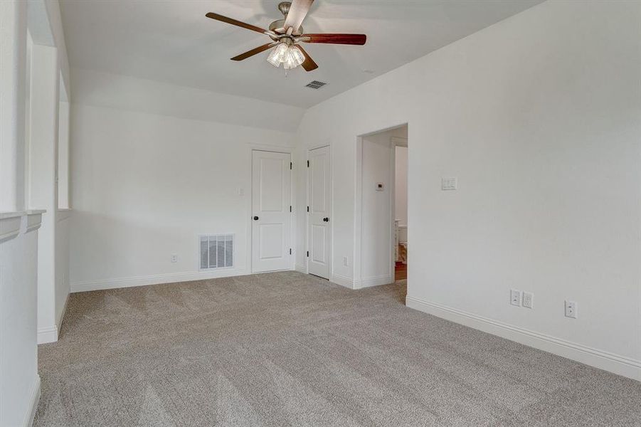 Empty room with light carpet, ceiling fan, and lofted ceiling