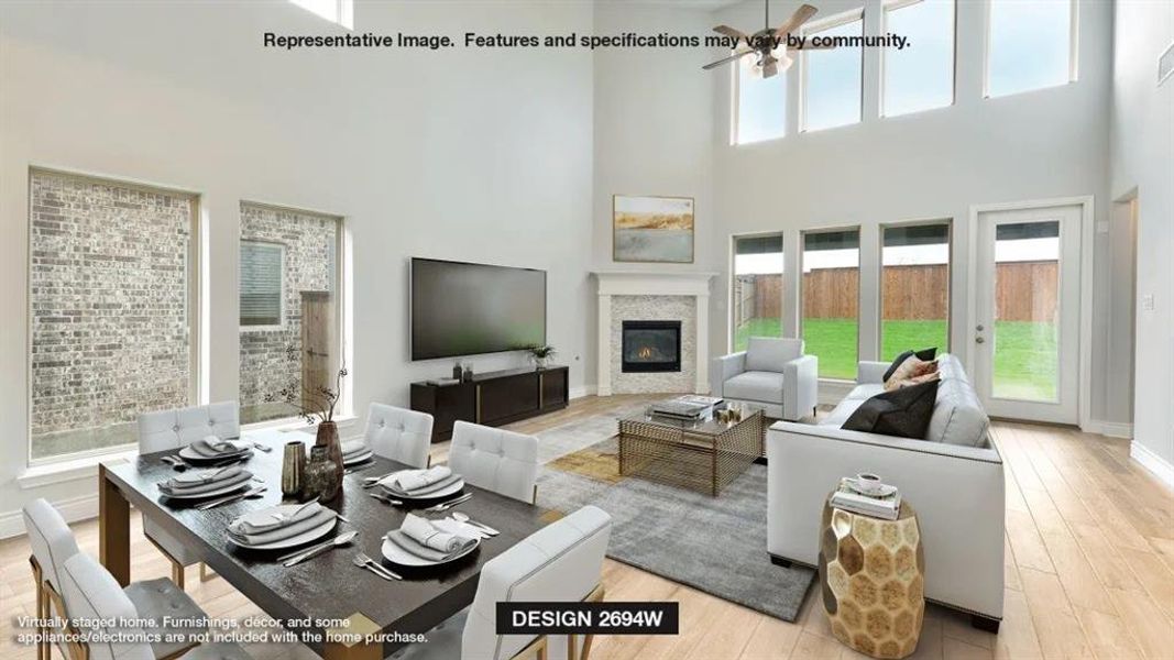 Living room with a towering ceiling, plenty of natural light, and light wood-type flooring